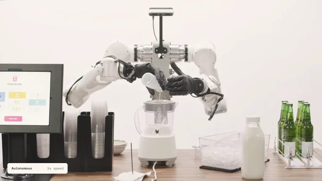 A dual-arm autonomous robot makes a milkshake by pouring ingredients into a blender, showing automation in the food service industry