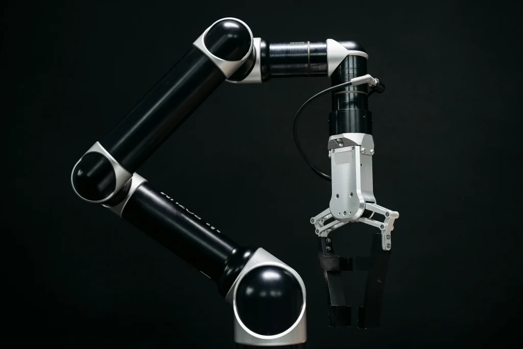 A sleek, modern robotic arm with a two-fingered gripper against a black background, showcasing advanced industrial design