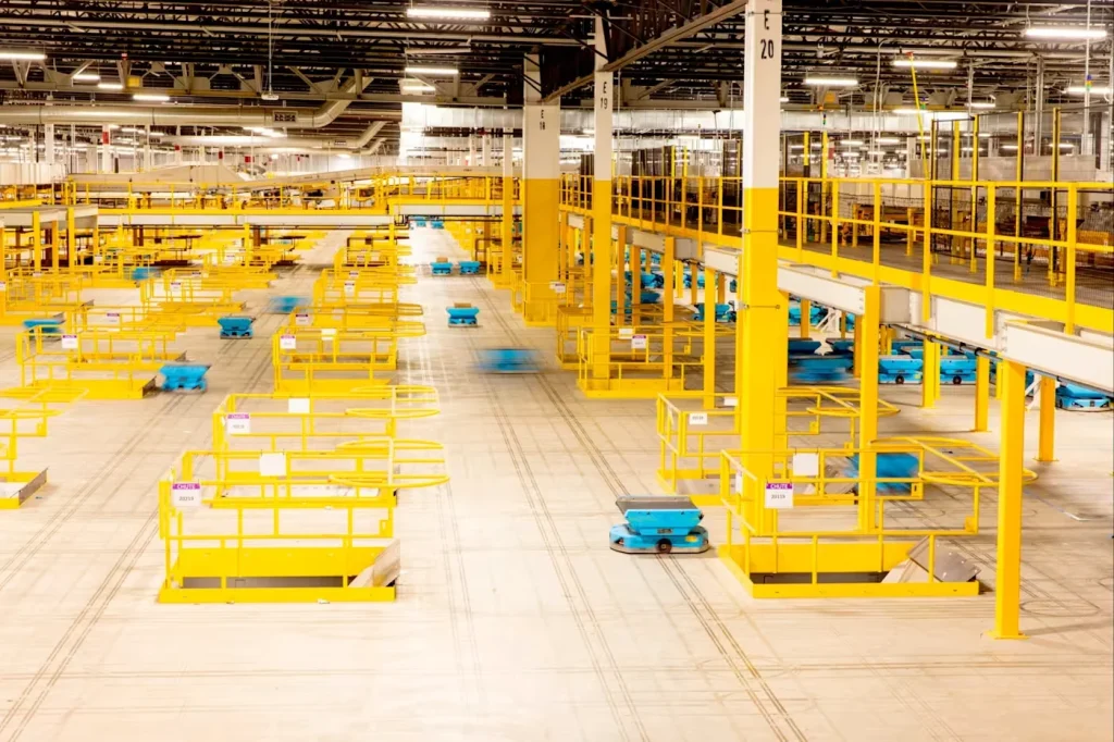 A large automated warehouse with a fleet of autonomous mobile robots (AMRs) moving efficiently across the floor for logistics