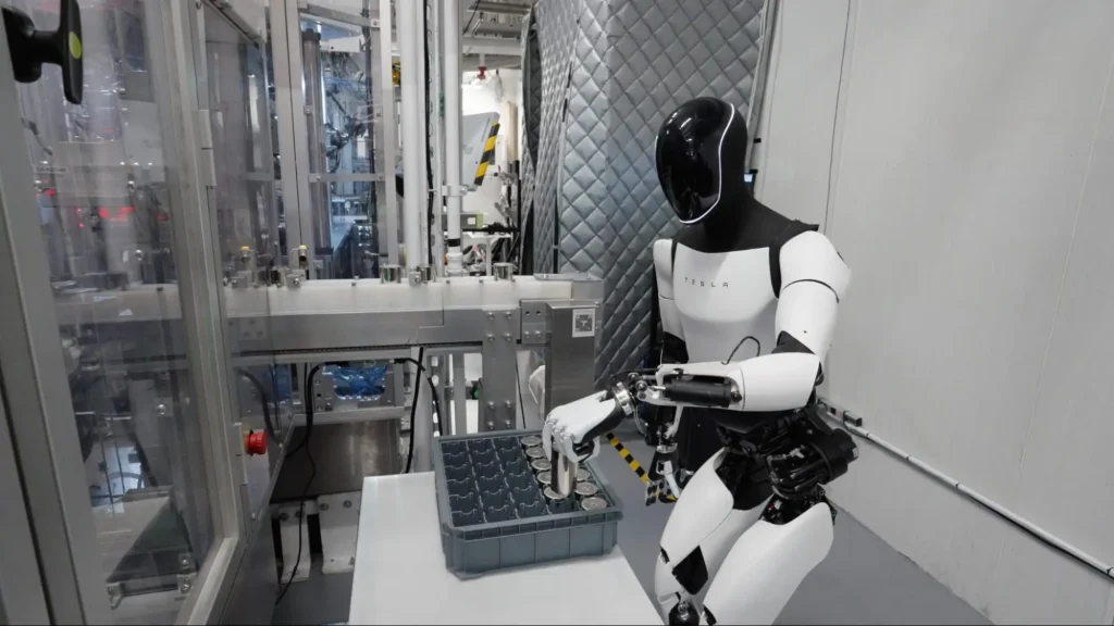 The Tesla Optimus humanoid robot performing a pick-and-place task on a factory assembly line, showcasing AI in manufacturing