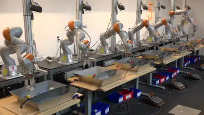Row of silver and orange robotic arms set up in a laboratory for automated sorting and pick-and-place testing