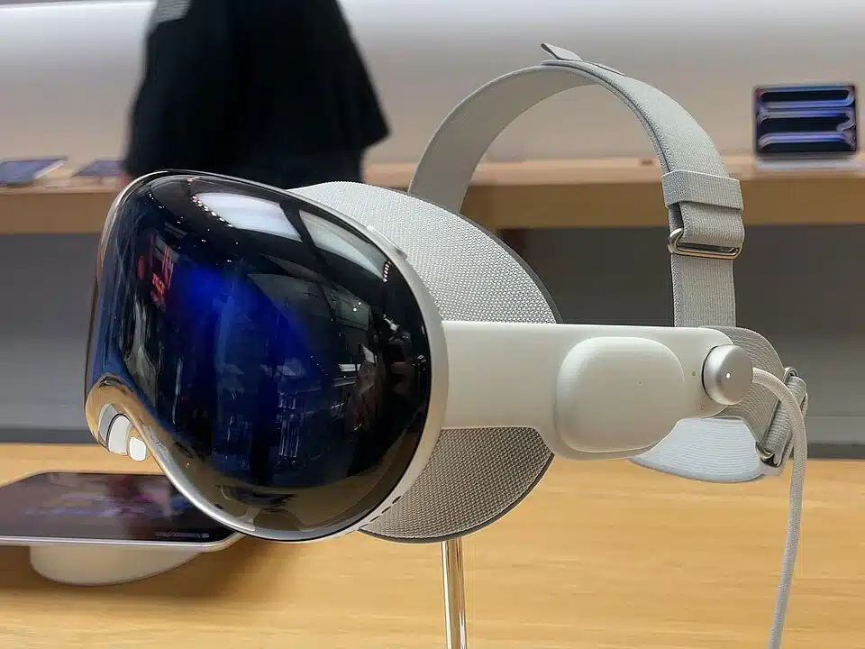 Apple Vision Pro spatial computing headset displayed on a stand, showing its front glass and strap