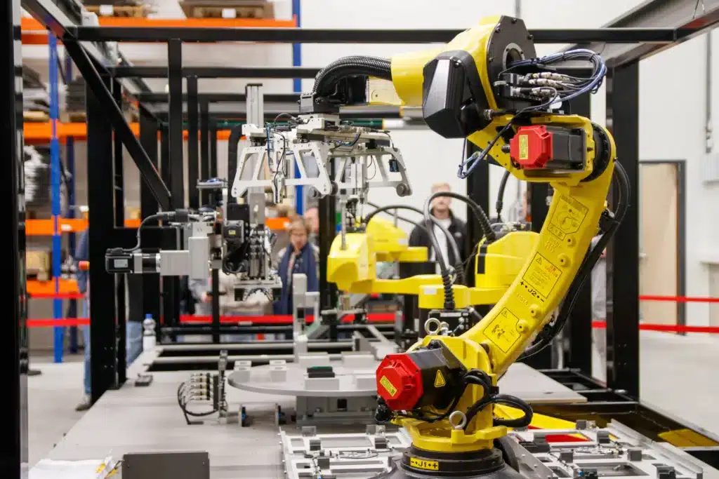 Yellow industrial robotic arms equipped with grippers assembled on a factory testing and assembly station