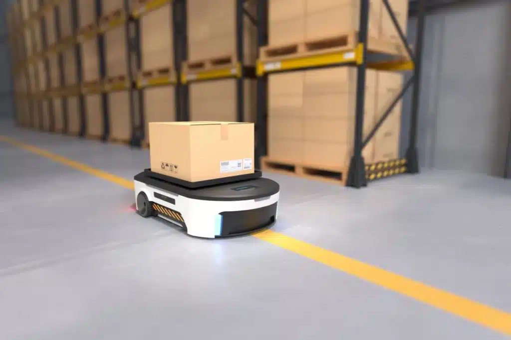An automated guided vehicle following a yellow floor guide to transport cardboard boxes in a warehouse