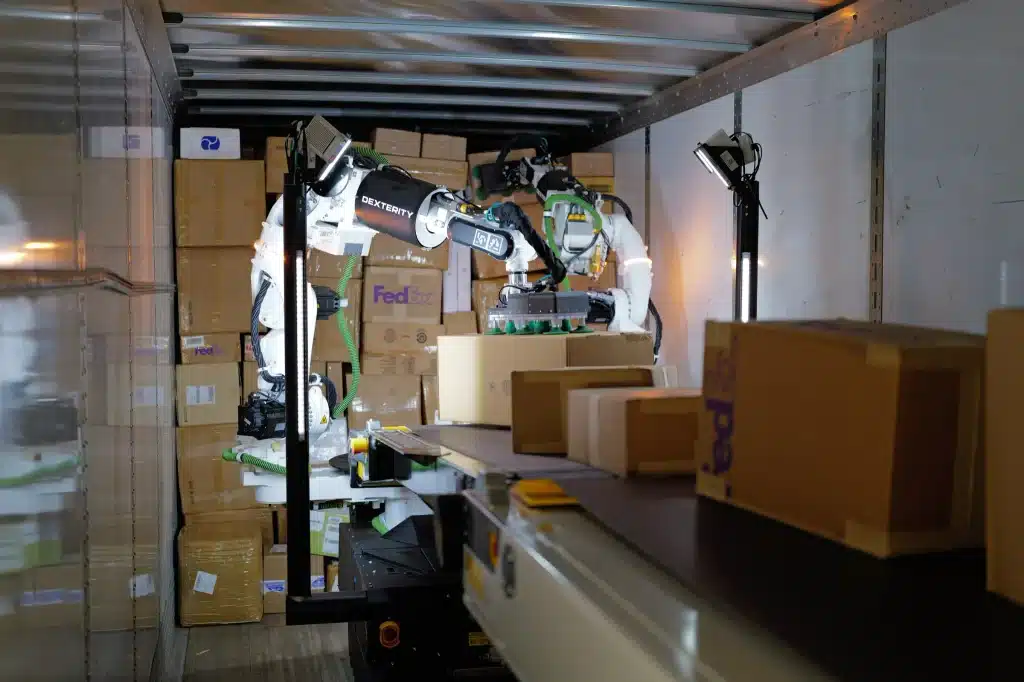 Dexterity AI robot unloading cardboard boxes inside a FedEx truck trailer.